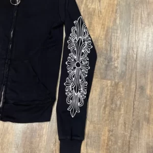 The Rare Chrome Hearts Floral Cross Track Jacket is a black zip-up track jacket featuring a floral cross design. This jacket is likely to be a limited edition or rare piece, and may be highly sought after by collectors and fans of the Chrome Hearts brand. The jacket is made of premium materials and is likely to be of high quality. The floral cross design is a unique and eye-catching feature that sets this jacket apart from other track jackets. It is likely to be a stylish and comfortable piece of clothing that can be dressed up or down depending on the occasion.